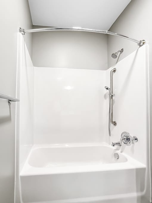 A white bathroom with a shower and tub.