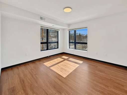 A Stryker Senior Apartments in West St. Paul living room with wooden flooring and a large window.