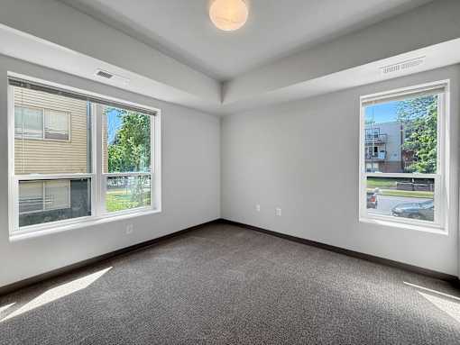 a bedroom with 2 large windows