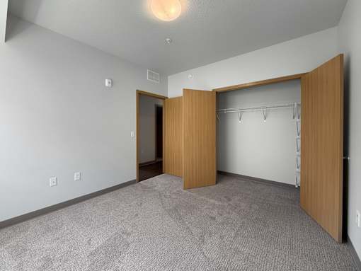 A room with a carpeted floor and a wooden door.