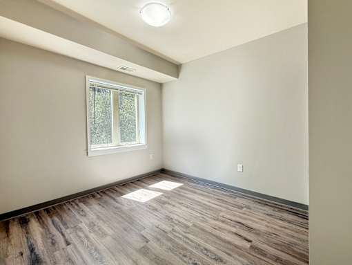 A room with wooden flooring and a window.