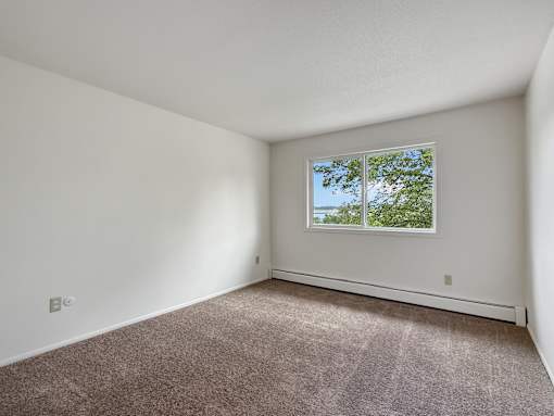 A room with a window showing trees outside.