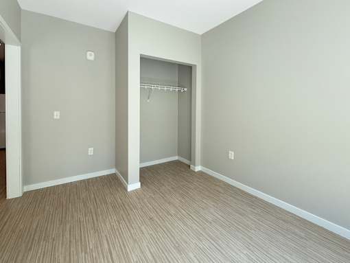 A room with a grey wall and a wooden floor.