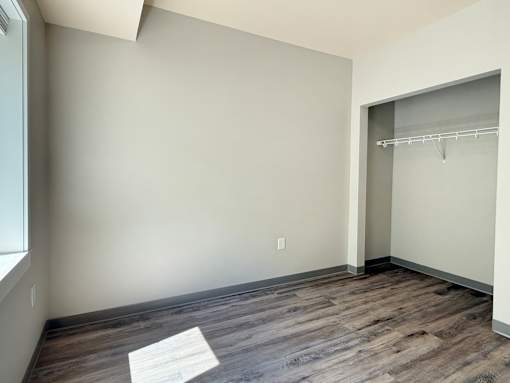 A room with a wooden floor and a white wall.