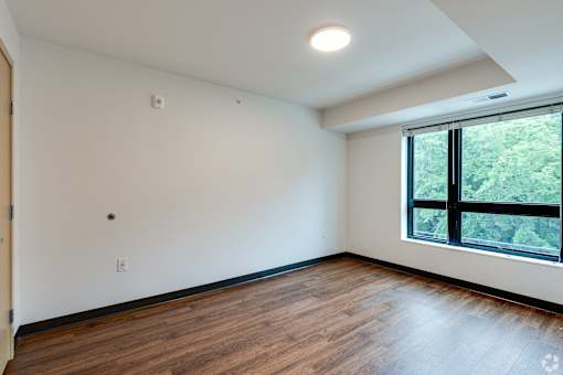 an empty living room at Stryker Senior Apartments in West St Paul with wood floors and a large window