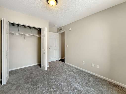 A room with a grey carpet and a white door.