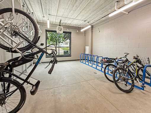 A bike is parked on a blue bike rack in a white room.