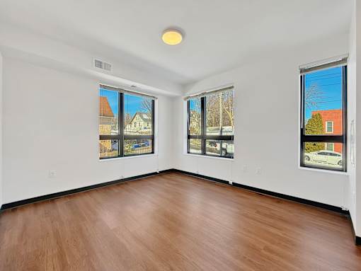 Another angle of a Stryker Senior Apartments in West St. Paul room with wooden floor and white walls, and big windows.