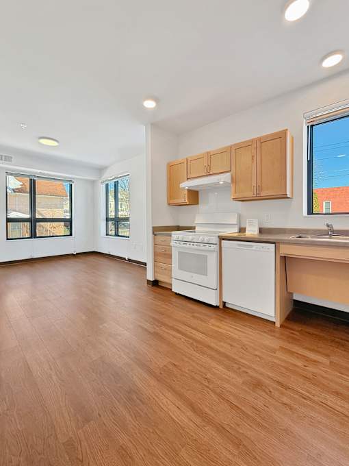 Another view of a Stryker Senior Apartments in West St. Paul  kitchen with wooden floors and white appliances.