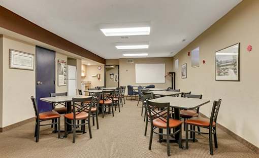 A room with tables and chairs is set up for a meeting.
