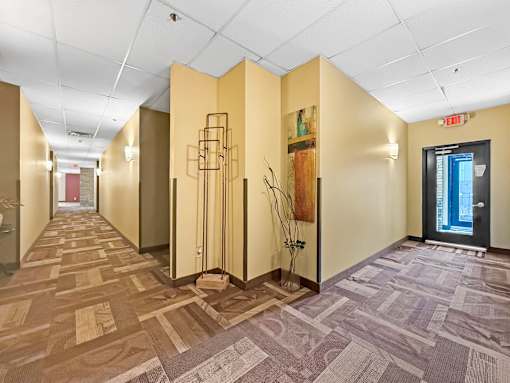 A hallway with tan walls and a carpeted floor.