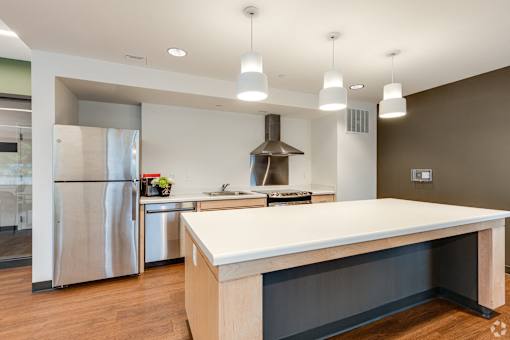 The Community Room kitchen at Stryker Senior Apartments in West St. Paul with a large island and a stainless steel refrigerator