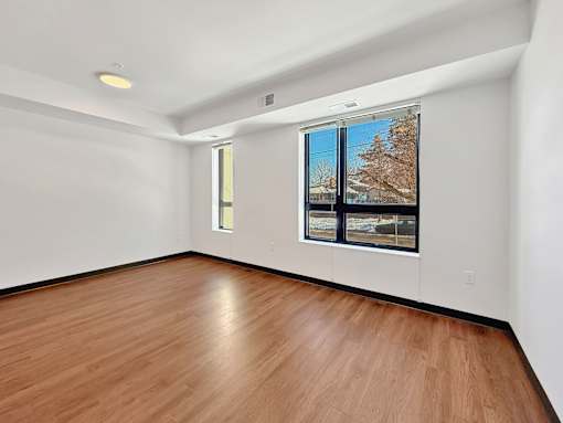 Another angle of a living room at Stryker Senior Apartments in West St. Paul with a window showing a tree outside.