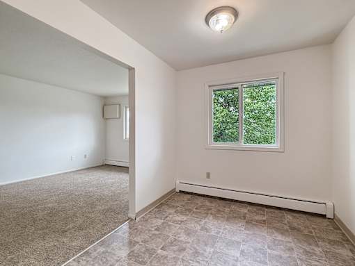 A room with a window and a tiled floor.