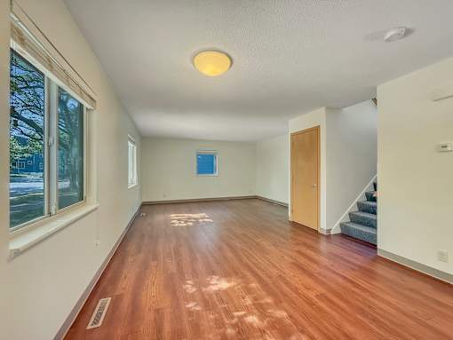 A room with wooden floors and a staircase.