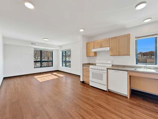 A Stryker Senior Apartments in West St. Paul apartmentkitchen with white appliances and wooden floors.