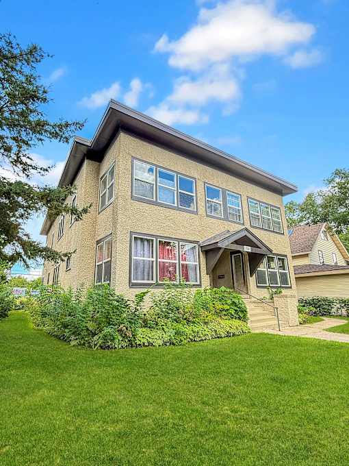 A house with a green lawn in front.