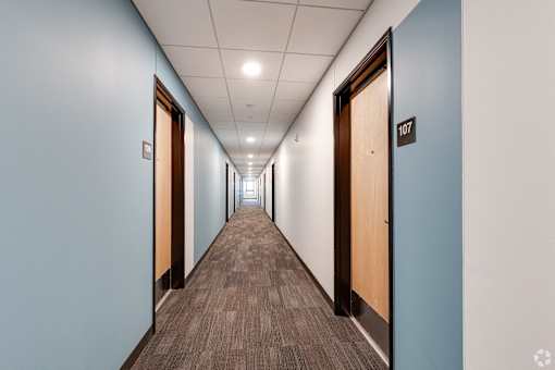 a Stryker Senior Apartments in West St Paul hallway with blue doors and white walls and a wooden floor