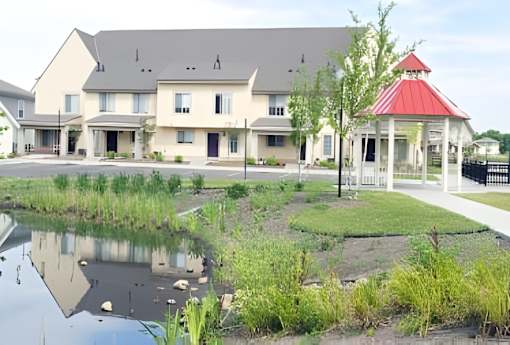 A house with a red roof is reflected in the water.
