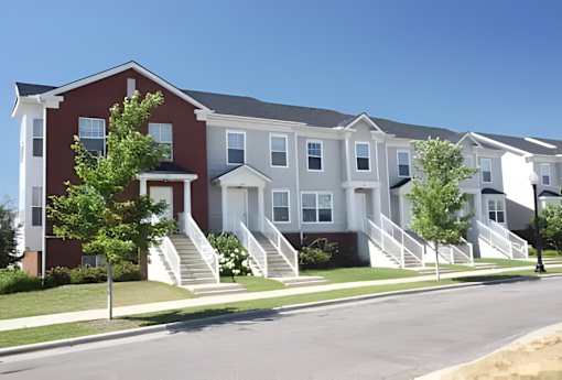 A row of townhouses with a clear blue sky above.