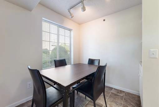 A dining room with a table and chairs.