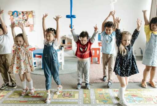 A group of children are playing with a cross in a room.