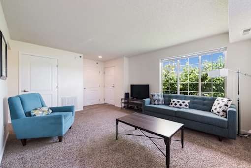 A living room with a blue chair and a blue couch.
