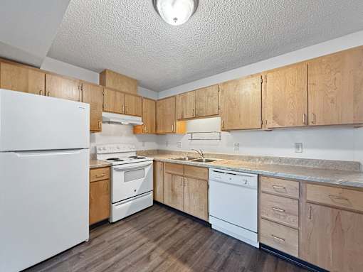 A kitchen with wooden cabinets and white appliances.