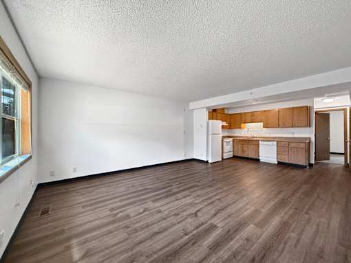 A kitchen with wooden floors and white walls.