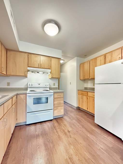 A kitchen with wooden cabinets and a white refrigerator.