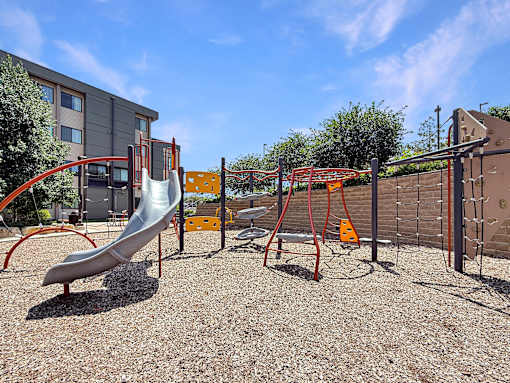 A playground with a slide, swings, and a climbing frame.