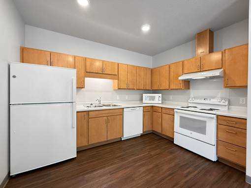 A kitchen with wooden cabinets and white appliances.