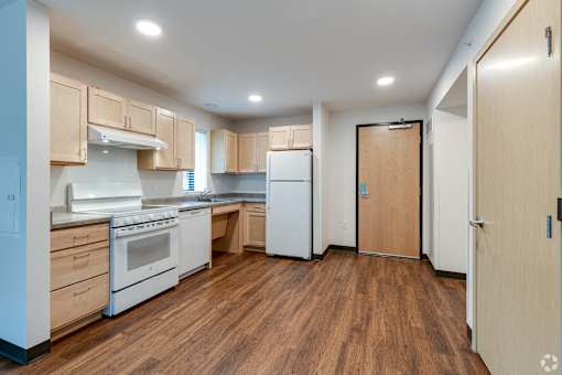 Another Stryker Senior Apartments in West St. Paul kitchen with white appliances and wood flooring