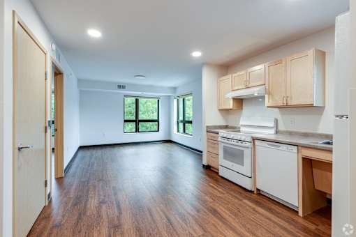 a Stryker Senior Apartments in West St Paul kitchen and living room with wood floors and white appliances
