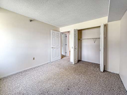A room with a carpeted floor and white walls.
