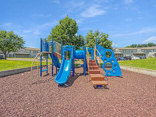 A playground with a blue slide and a brown slide.