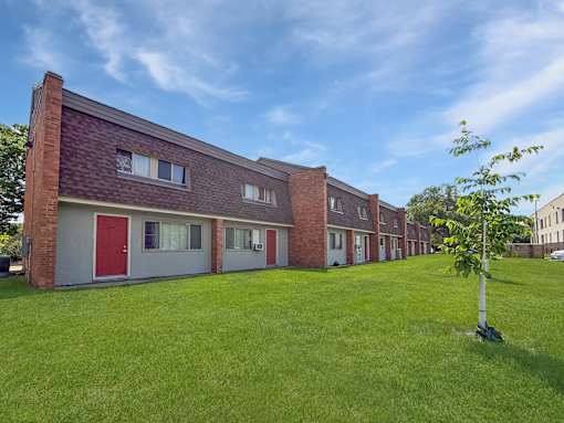 A photo of a green lawn and blue skies over Liberty Plaza Townhome and Apartments