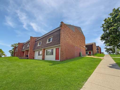 A photo of Liberty Plaza Townhomes with green lawn and blue skies