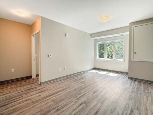 A room with wooden flooring and a window.