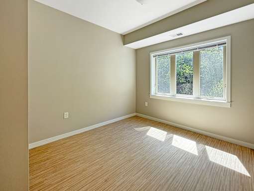 A room with a window and wooden flooring.