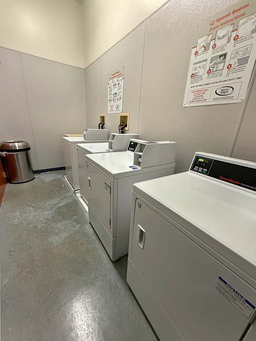 A clean, white-walled laundry room with a washer and dryer.