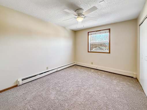 A room with a ceiling fan and a window.