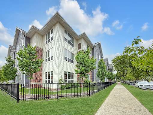 A row of houses with a black fence in front.