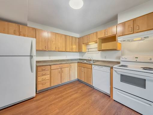 A kitchen with wooden cabinets and white appliances.