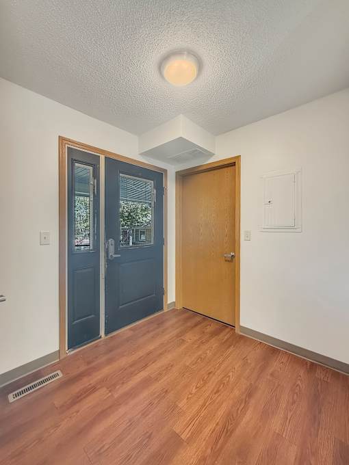 A room with a wooden floor and a white ceiling with a light fixture.