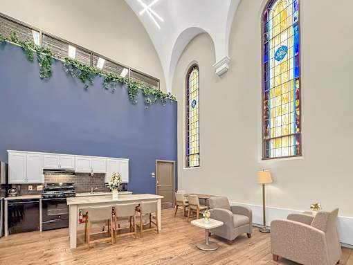 A kitchen with a table and chairs in front of a stained glass window.
