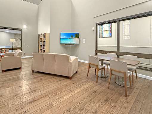 A living room with a couch, chairs, and a television.