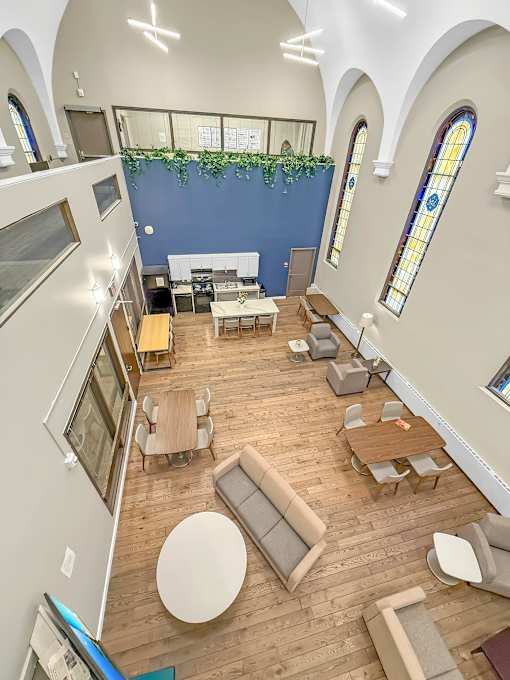 A church interior with wooden floors and white furniture.