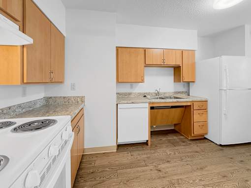 A kitchen at Stonehouse Square Apartments with white appliances