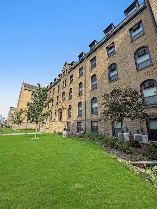 A large grassy area in front of a brick building.